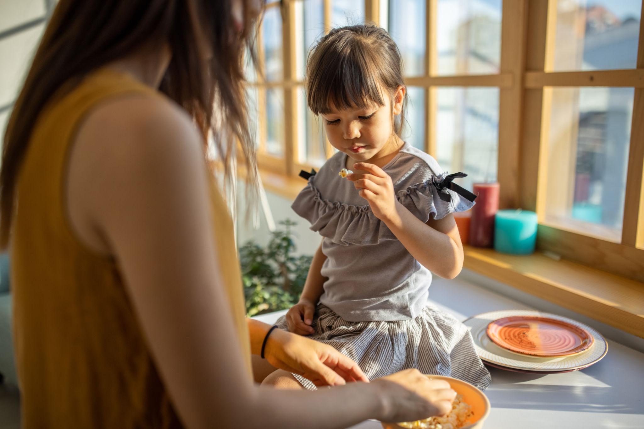 Hình ảnh trẻ thưởng thức bánh sữa trong không gian gia đình sáng thoáng, phù hợp với bối cảnh bữa phụ hằng ngày.