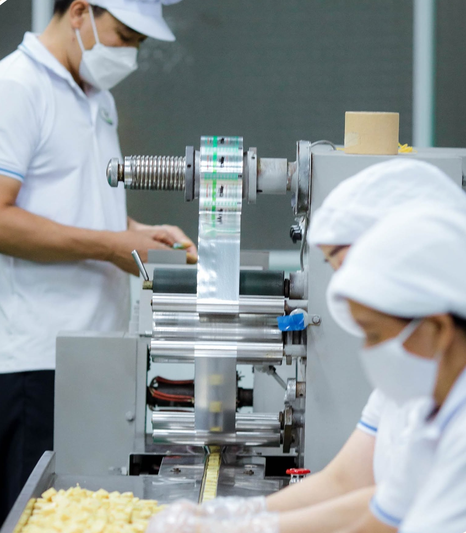 Bánh Sữa Làm Từ Gì? Khám Phá 75% Sữa Tươi Trong Bánh Kẹo Sữa Long Thành 4 Nhân viên Domilk thực hiện công đoạn đóng gói bánh sữa bằng máy móc tại nhà máy sản xuất.